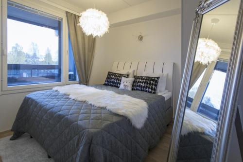 a bedroom with a large bed and a mirror at Vasko Luxurious Suites, Nilo in Rovaniemi