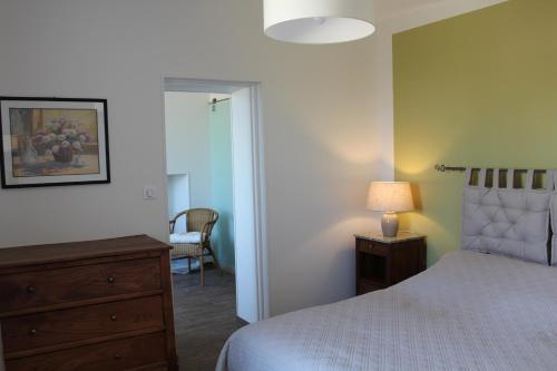a bedroom with a bed and a dresser and a lamp at Gîte Domaine St Georges in Bagneux