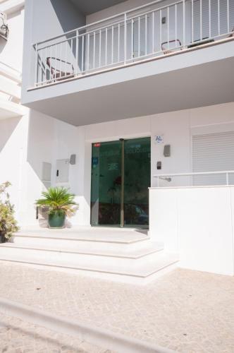 a white building with a staircase and a plant at Boutique & Villas Boliqueime in Boliqueime