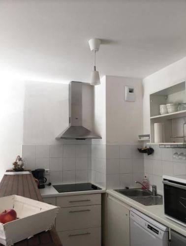 une cuisine avec un évier et une cuisinière four supérieur dans l'établissement Charmant appartement - Centre d'Arcachon, à Arcachon