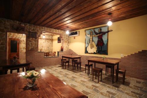 una sala da pranzo con tavoli e un dipinto sul muro di Hotel Harmony a Kutaisi