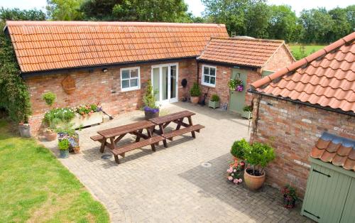 a patio with a wooden picnic table in front of a building at Jockhedge Holiday Cottages in Skegness