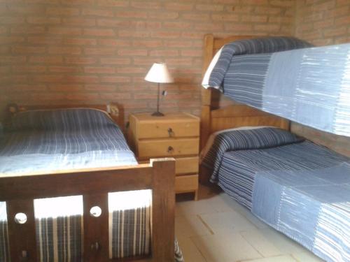 een slaapkamer met 2 stapelbedden en een nachtkastje bij Postal Serrana in Villa Parque Siquiman