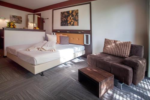 sypialnia z łóżkiem i skórzanym krzesłem w obiekcie Hotel Lifestyle w mieście Landshut