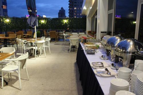 a table with plates and dishes on it on a patio at New Baku Hotel in Baku