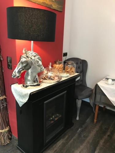 a table with a fireplace with a horse statue on it at Hotel Heddernheimer Hof in Frankfurt/Main