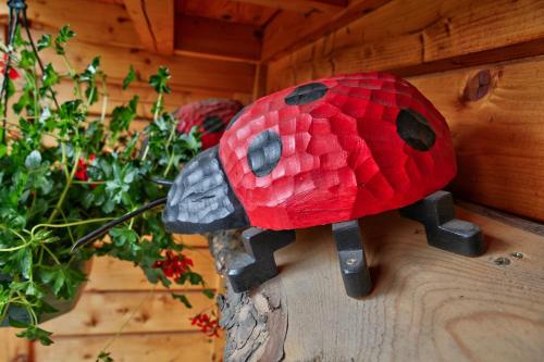 a red mushroom on a wall next to some plants at Les Chalets du Mazet Saint Voy in Mazet-Saint-Voy