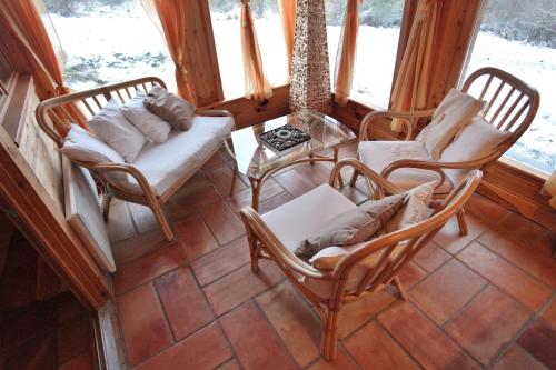 a screened in porch with chairs and a table at Les Chalets du Mazet Saint Voy in Mazet-Saint-Voy