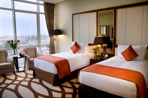 a hotel room with two beds and a large window at Bayat Hotel in Khamis Mushayt