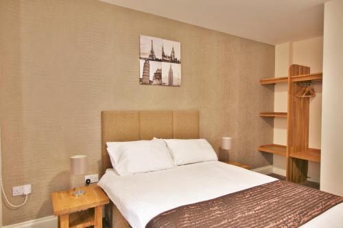 Ένα ή περισσότερα κρεβάτια σε δωμάτιο στο Central Studios Gloucester Place by Roomsbooked