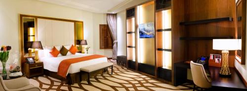a hotel room with a bed and a desk and chairs at Bayat Hotel in Khamis Mushayt