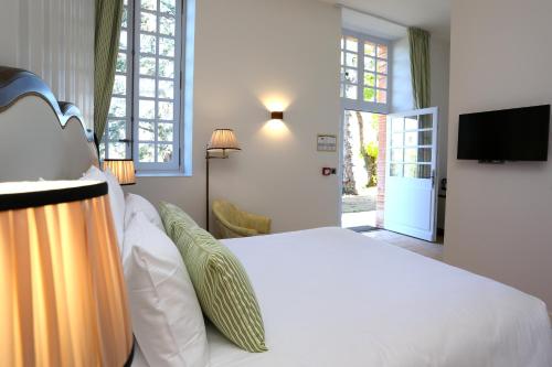 a bedroom with a white bed and a tv at Chateau de Drudas in Drudas