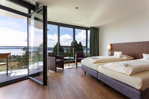 a hotel room with two beds and a balcony at Parkhotel St.Leonhard in Überlingen