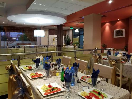 un comedor con una mesa con platos de comida en Hotel Orlovetz, en Gabrovo