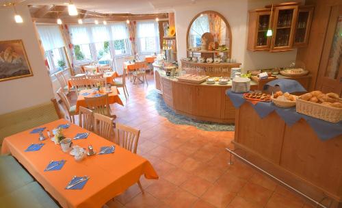 een restaurant met tafels en stoelen met eten erop bij Hotel Garni Ida in Ischgl