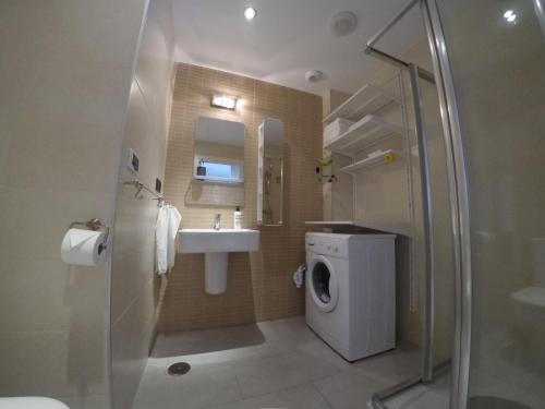 ein Badezimmer mit einem Waschbecken und einer Waschmaschine in der Unterkunft Penthouse La Zenia in Playa Flamenca