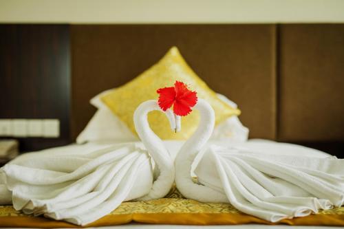 2 cygnes faits de serviettes sur un lit dans l'établissement Jing Pin Hotel, à Koror
