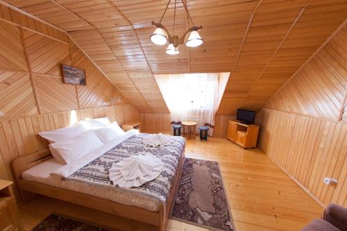a bedroom with a bed in a wooden room at Edelweiss Carpathians Migovo in Migovo