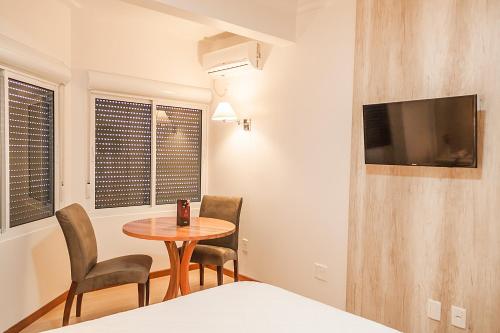 a room with a table and two chairs and a tv at Hotel Solaris in São Miguel dʼOeste