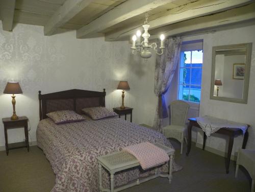 - une chambre avec un lit, une fenêtre et un lustre dans l'établissement Chambres d'hôtes du Perray, à Candé