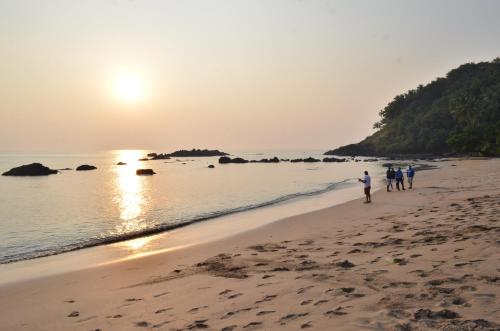 a group of people walking on the beach at Cola Beach Sunset Bay in Cola