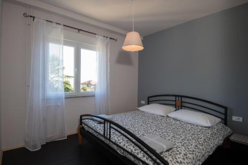 a bedroom with a bed and a window at Apartment Sebalj in Opatija