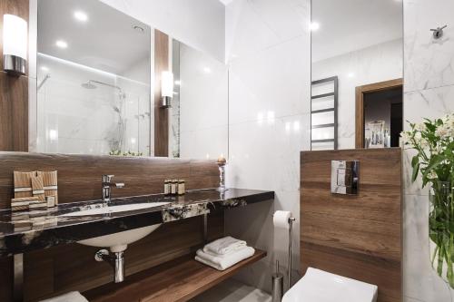 a bathroom with a sink and a mirror at Aparthotel Best Views in Krakow