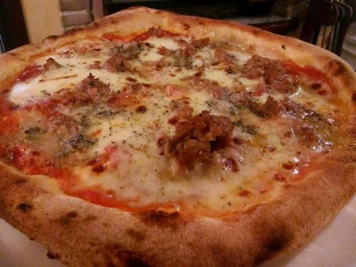 a cheese pizza sitting on top of a white plate at Il Castello in Petralia Sottana