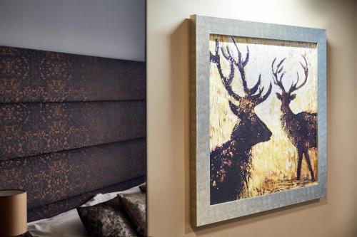 a painting of deer on the wall of a bedroom at Aparthotel Best Views in Krakow