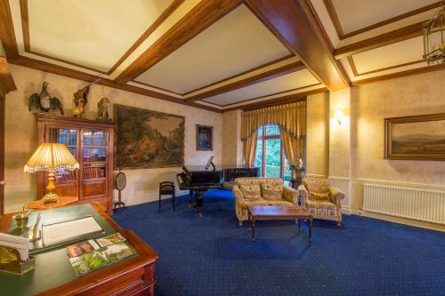 a living room with a piano and a couch at Lake Vyrnwy Hotel & Spa in Llanwddyn