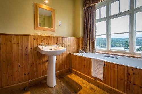 a bathroom with a sink and a bath tub at Lake Vyrnwy Hotel & Spa in Llanwddyn