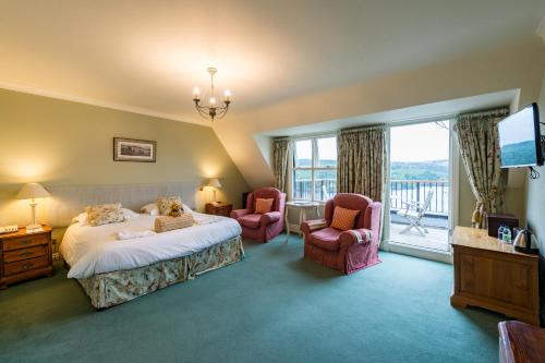 a hotel room with a bed and two chairs at Lake Vyrnwy Hotel & Spa in Llanwddyn