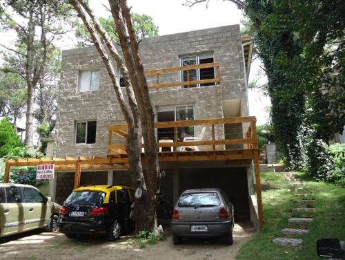 una casa con coches aparcados frente a Gorriones Libres en Villa Gesell