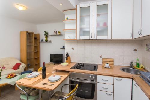 een keuken met een tafel, een wastafel en een fornuis bij Apartment Family Tokic in Dubrovnik