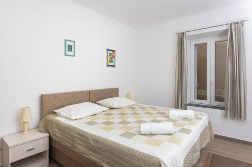 - une chambre avec un lit et une couverture en damier dans l'établissement Apartment Family Tokic, à Dubrovnik