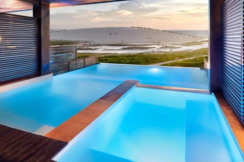 een zwembad in een huis met uitzicht op het strand bij Essenza Dune Hotel in Jericoacoara