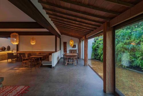 a dining room with a table and chairs and a large window at Capim do Mato Pousada & Spa by L'Occitane in Serra do Cipo