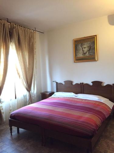 a bedroom with a bed and a window at Locanda Al Cavaliere in Molinella
