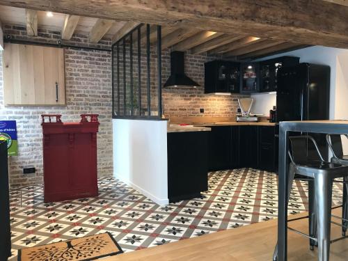 - une cuisine avec des armoires noires et un réfrigérateur rouge dans l'établissement Chambres d'hôtes Saint Jean, à Nogent-le-Rotrou