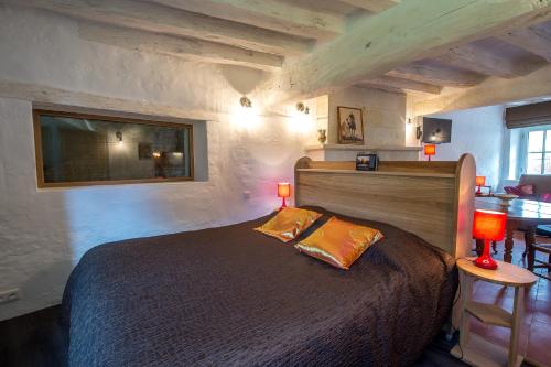 a bedroom with a large bed with two lamps on it at En Rou Libre in Rou-Marson