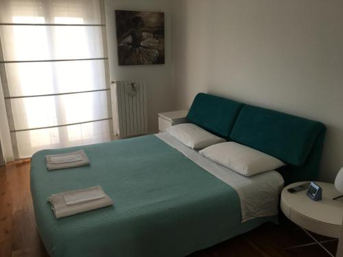 1 dormitorio con 1 cama verde y 2 almohadas en Flowers Apartment, en Bari