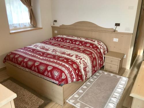 a bedroom with a bed with a red blanket on it at Genzianella Mansarda Molveno-Andalo in Molveno
