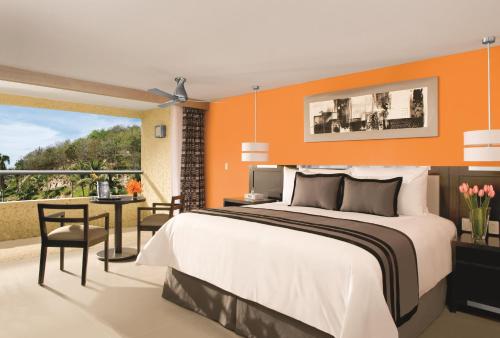 - une chambre avec un grand lit et un balcon dans l'établissement Dreams Huatulco Resort & Spa, à Santa Cruz Huatulco