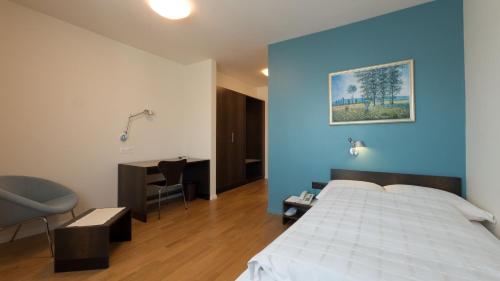 Hotel Terminus Brugg في بروغ: غرفة نوم بسرير وجدار ازرق
