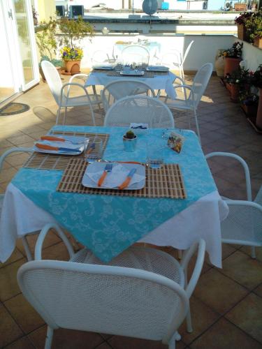 a table with a blue table cloth and white chairs at B&B Celestina Ischia in Ischia