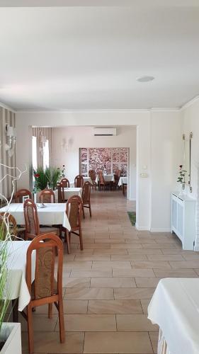 jadalnia ze stołami i krzesłami oraz pokój z białymi ścianami w obiekcie Restauracja i Noclegi Pod Sikorką w mieście Kobior