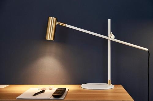 a desk with a lamp and a remote control on it at Hotel Randers in Randers