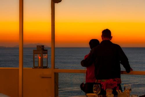 a man and a woman looking at the sunset at Hotel Pocho in San Vito lo Capo