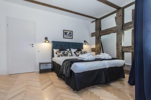 een slaapkamer met een groot bed en een houten vloer bij Heritage House in Klaipėda
