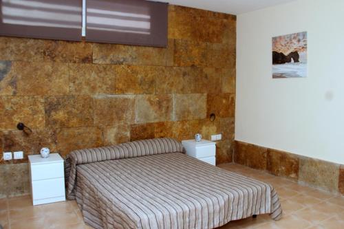 コスタ・デ・アンティグアにあるDuplex Janeのレンガの壁、ベッド付きのベッドルーム1室